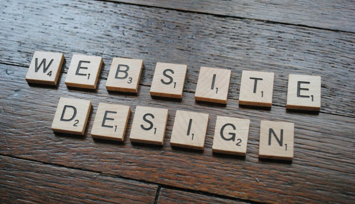 Brown wooden table with the words “Website Design” displayed, representing choosing the right website design for a church.