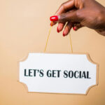 Hand holding a poster that says “Let’s Get Social,” symbolizing church engagement through social media platforms